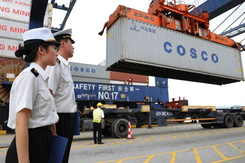 Shipping container being loaded at a Chinese export port under supervision during a managed supplier shipment
