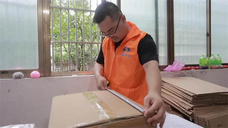 Goodcantrading staff measuring an export carton to calculate chargeable volume before a container is loaded